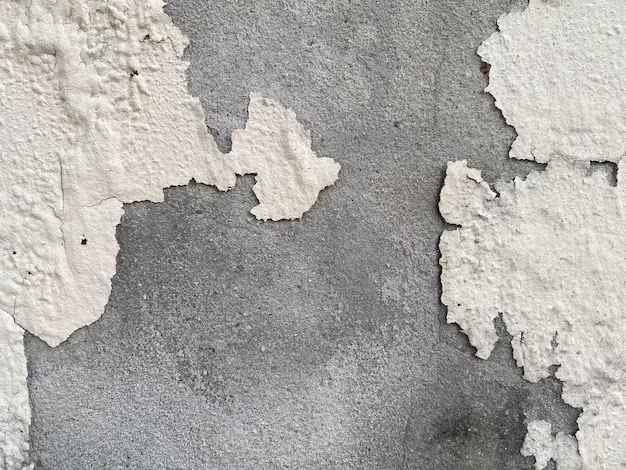 Серая стена с белой краской, которая треснула и имеет дыру посередине с надписью «белая краска».